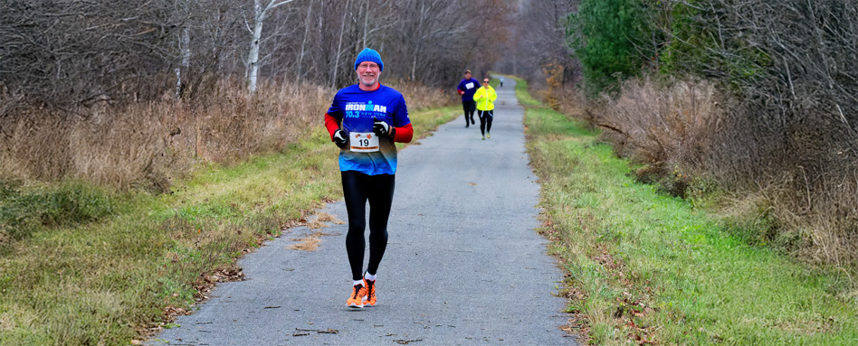 A person jogging on a paved trail A person jogging on a paved trail